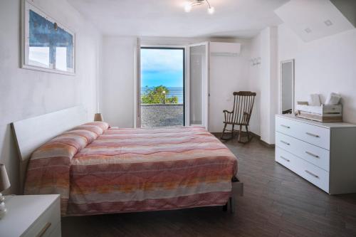 um quarto com uma cama grande e uma janela em casa Ciapin em Cipressa