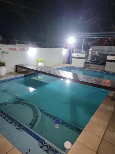 a large swimming pool at night with lights at The wood Guest house in Pretoria