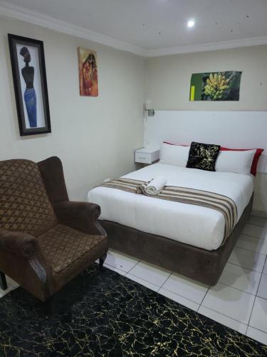 a bedroom with a bed and a chair in it at The wood Guest house in Pretoria