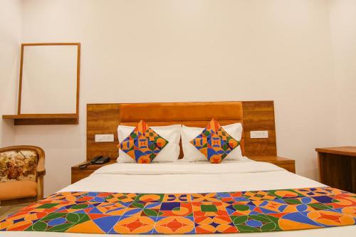 a bedroom with a bed with a colorful comforter at FabHotel Ambassador in Chandīgarh