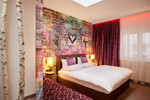 ein Schlafzimmer mit einem Bett und einer Ziegelwand in der Unterkunft Trihotel Rostock - Wellnesshotel Adults Only in Rostock