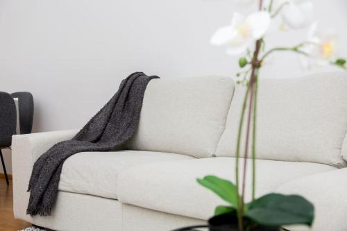 a white couch with a black blanket on it at OrestaLiving - 2BR On the Danube Canal in Vienna