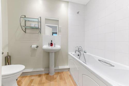 a white bathroom with a sink and a toilet at City Penthouse with Scenic View Balcony in Milton Keynes
