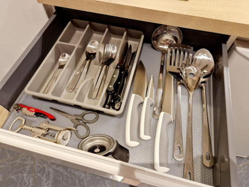 un tiroir rempli d'ustensiles en argent dans une cuisine dans l'établissement Nid perché en Triplex - Haguenau Centre - Wi-Fi, à Haguenau