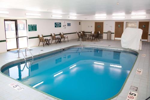 a large swimming pool in a room with tables and chairs at Comfort Inn Sioux City South in Morningside