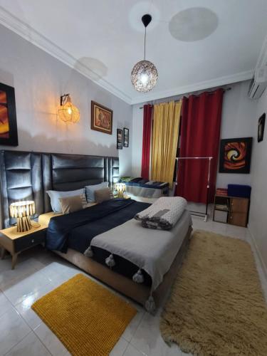 um quarto com uma cama grande e um sofá em Immeuble walili em Fez