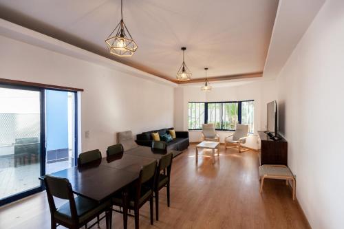 a dining room and living room with a table and chairs at FLH Caparica Town House with Pool in Costa da Caparica