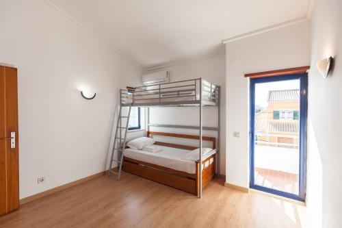 a bedroom with a bunk bed and a window at FLH Caparica Town House with Pool in Costa da Caparica