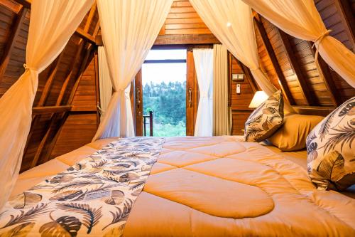 Bett in einem Zimmer mit Fenster in der Unterkunft The Pyramid Ubud River Villas in Gianyar