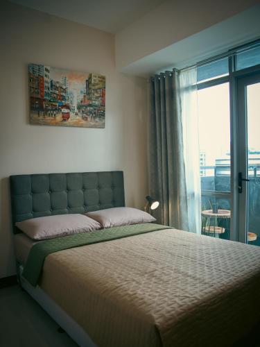 a bedroom with a large bed and a window at The Bat Cave 2 @Manhattan Heights in Manila