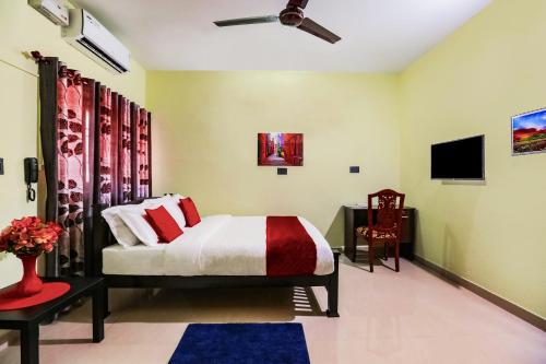 a bedroom with a bed and a tv in it at Urban Rose Homestay in Kannur