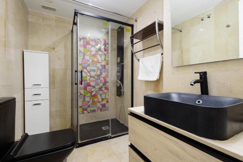 ein Bad mit einem schwarzen Waschbecken und einer Dusche in der Unterkunft Apartment on the 1st line of golf and near the beach in Marbella in Marbella