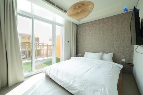 sypialnia z białym łóżkiem i dużym oknem w obiekcie Modern 3BR Villa, DAMAC Hills 2 w Dubaju