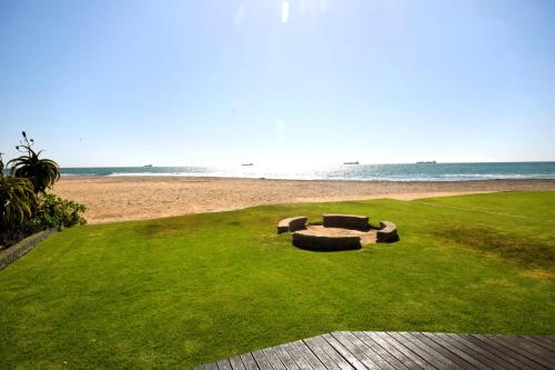 una panchina sull'erba vicino alla spiaggia di Ocean Dream Self-Catering a Swakopmund