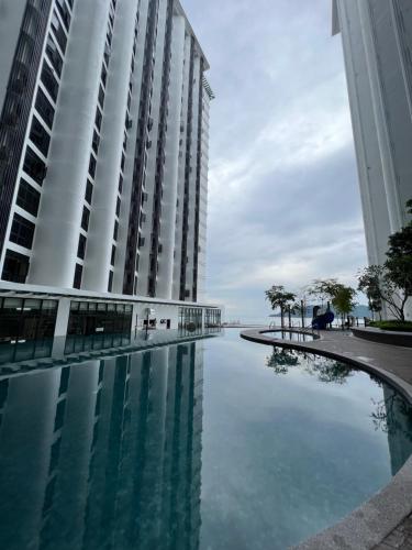 a swimming pool in front of a tall building at NOSTRE HOMESTAY THE SHORE KK in Kota Kinabalu