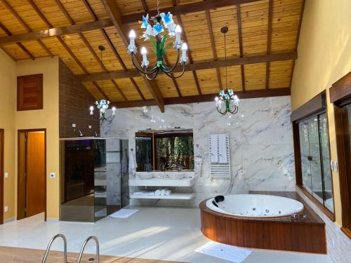 a large bathroom with a tub and a sink at Chalés Recanto das Montanhas in Monte Verde