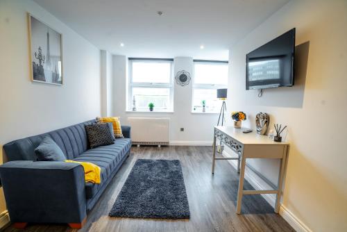 a living room with a blue couch and a desk at Stunning 1 bed flat in the heart of Brighton lanes in Brighton & Hove