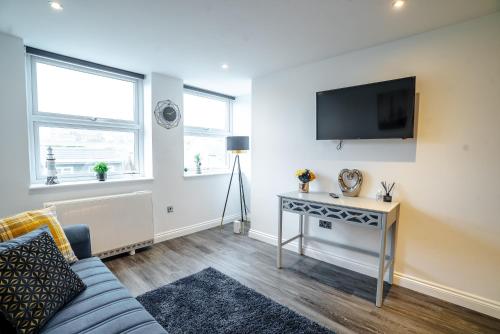 uma sala de estar com um sofá e uma televisão na parede em Stunning 1 bed flat in the heart of Brighton lanes em Brighton & Hove
