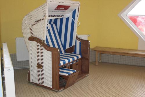 una sedia a dondolo e una scatola in una stanza di Residenz Ostseestrand Nr_ 11 a Scharbeutz