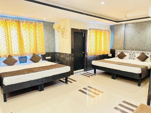 1 Schlafzimmer mit 2 Betten und gelben Vorhängen in der Unterkunft Nakshatra Hotel in Bānswāra