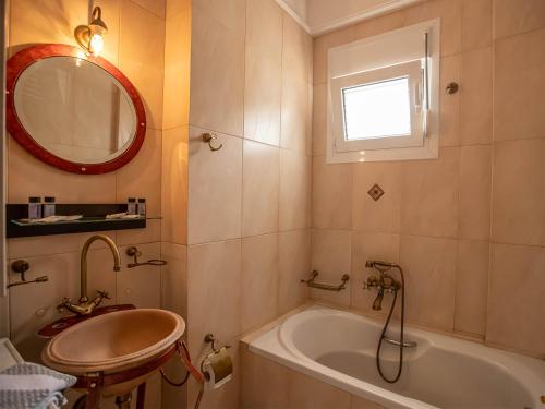 a bathroom with a tub and a sink and a mirror at Villa Portitsa in Kardítsa