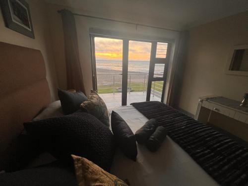 a bedroom with a bed with a view of the ocean at Ocean Dream Beach Cottage in Swakopmund