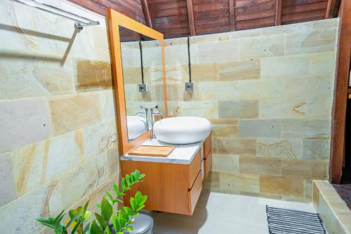 a bathroom with a sink and a mirror at The Pyramid Ubud River Villas in Gianyar