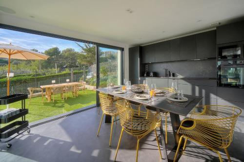 une cuisine avec une table et des chaises jaunes ainsi qu'une grande fenêtre dans l'établissement IMMOGROOM - Superbe villa - Piscine - Vue mer - Parking - Clim, à Vallauris
