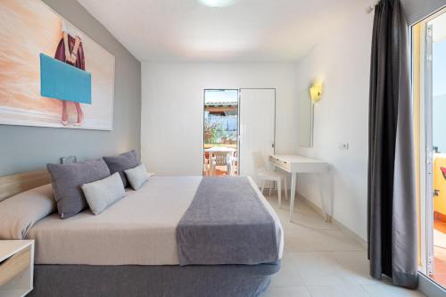 ein Schlafzimmer mit einem großen Bett und einem Schreibtisch in der Unterkunft Hotel Cenit & Apts. Sol y Viento in Ibiza-Stadt
