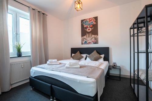 una camera da letto con un letto e un quadro sul muro di MIRA StudioApartments NEU a Castrop-Rauxel