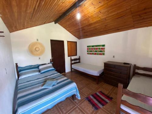 1 dormitorio con cama y techo de madera en Pousada Nikimba, en São Roque de Minas