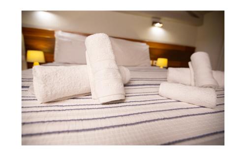 a bed with white towels and pillows on it at Daphne superior castle suite in Monemvasia