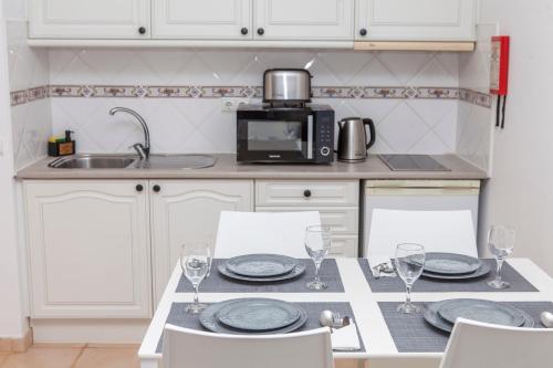 a kitchen with a table with plates and wine glasses at Atalaia Sol Aparthotel - tennis & heated pool in winter in Lagos