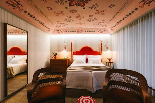um quarto com uma cama com um espelho e 2 cadeiras em Solar de Vila Meã em Barcelos