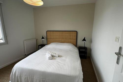 a bedroom with a white bed with two towels on it at Maison Style & Espace à Angers in Angers
