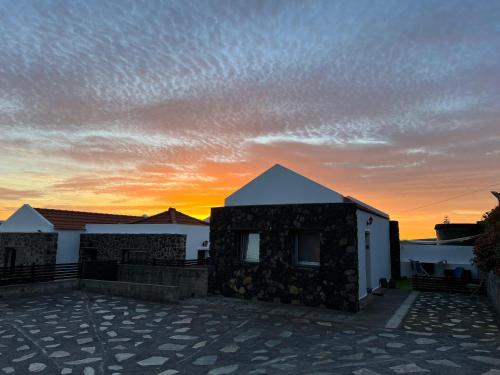 una casa con una puesta de sol en el fondo en Apartamento MAYATA DELUXE, en Mazo