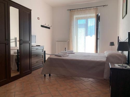 a bedroom with a bed and a dresser and a window at Albori in San Severino Lucano