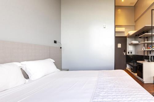 a bedroom with a large white bed with white pillows at Tri Hotel Premium Itapema in Itapema