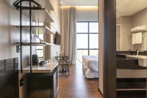 Tri Hotel Premium Itapema في ايتابيما: غرفة مع مطبخ وغرفة معيشة
