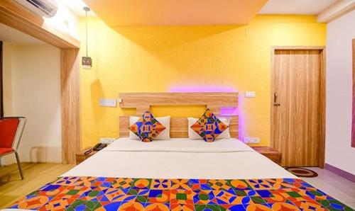 sypialnia z dużym łóżkiem z kolorową narzutą w obiekcie FabHotel Sai Jagannath Residency w mieście Khandagiri