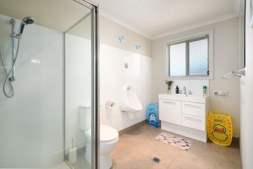 a bathroom with a toilet and a glass shower at Breeza Haven - Your Home Away From Home in Kingston