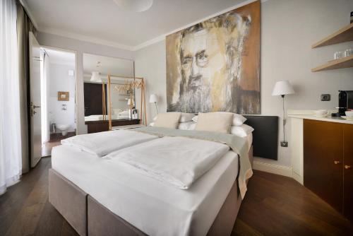 een slaapkamer met een groot bed en een schilderij aan de muur bij Design Hotel Neruda in Praag