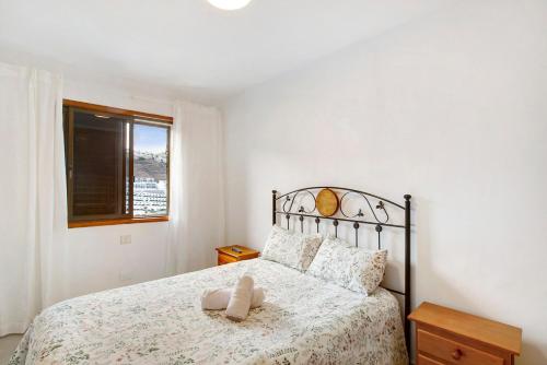 Un dormitorio con una cama con un edredón blanco. en Bellavista, en Puerto Rico de Gran Canaria