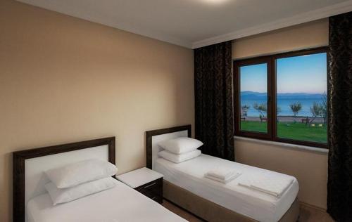 a hotel room with two beds and a window at JURA HOTELS ALTINOLUK THERMAL in Avcılar