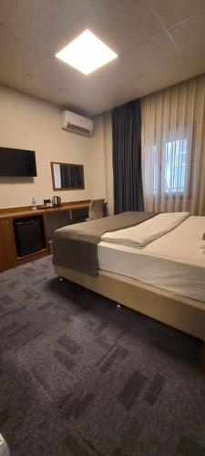 a bedroom with a large bed and a television at My Rezidans Hotel in Manisa