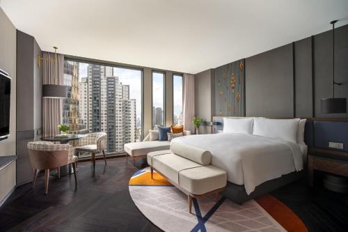 una camera con un grande letto e un soggiorno di InterContinental Bangkok Sukhumvit, an IHG Hotel a Bangkok