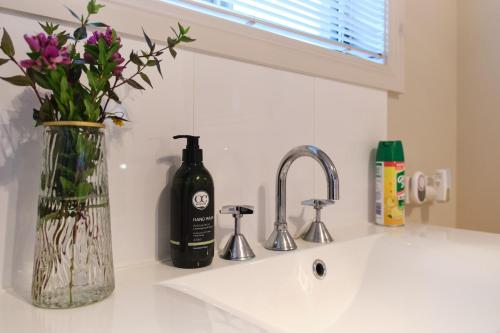 a bottle of wine sitting on top of a sink at Breeza Haven - Your Home Away From Home in Kingston