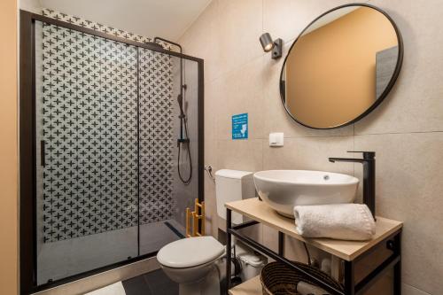 a bathroom with a sink and a shower with a mirror at Apartments & rooms ONE WORLD in Rijeka