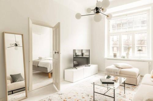 Sala de estar blanca con espejo y cama en Downtown Light-Filled Retreat, en Helsinki