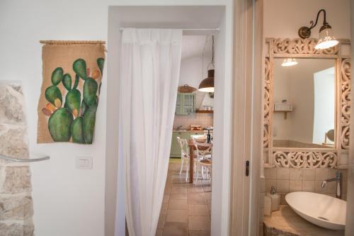 ポリニャーノ・ア・マーレにあるTrulli Dimore - Casa Fusellaのバスルーム(白いシャワーカーテン付)が備わります。